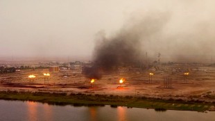 Flares at Iraqi oil field are shown burning gas next to villages