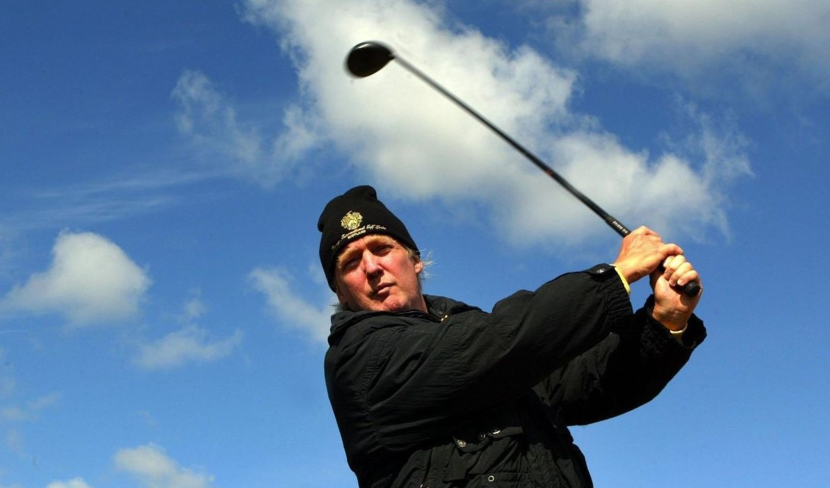 Donald Trump swings a golf club on a Scottish golf course