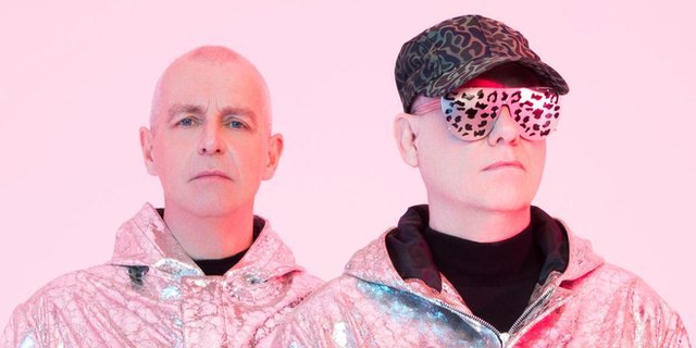 Pet Shop Boys wearing silver-coloured tracksuit tops against a pink background