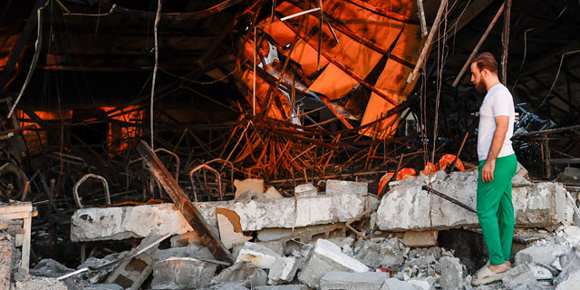 A person looks at the damage at the site following a fatal fire at a wedding celebration, in Iraq