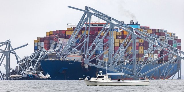 Wreckage from the Francis Scott Key Bridge sits on top of the Dali cargo ship after the crash