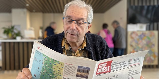 Francis, a man who has dementia, reads a newspaper in Landais Alzheimers