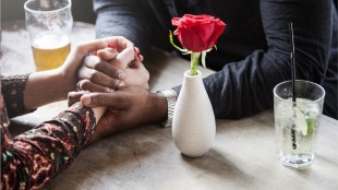 A couple hold hands over a table