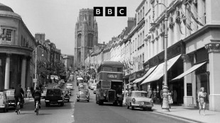 A black-and-white scene from a street in Bristol in the 1960s, including a double-decker bus