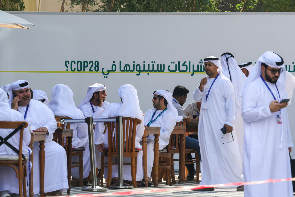 Men sit outside the venue of the COP28 United Nations climate summit in Dubai on 29 November 2023