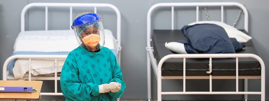 A health worker walks between beds at a temporary field hospital set up by Medecins Sans Frontieres during the coronavirus disease outbreak in Khayelitsha township near Cape Town, South Africa.