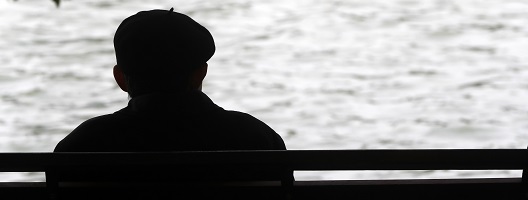 Silhouette of a man sitting on a bench