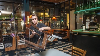 A bar tender in a pub in Manchester puts away chairs at the end of the evening