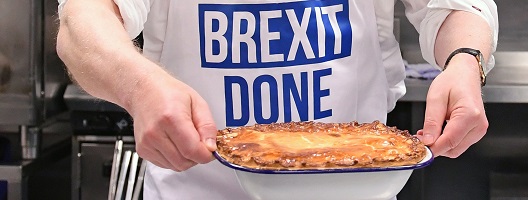 Close up of the PM's apron reading "Get Brexit Done" as he holds a pie