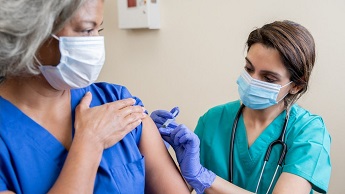 Stock image of a woman being given a vaccine