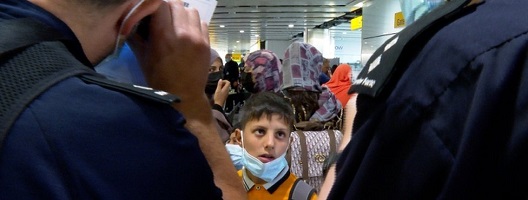 A boy looks on at border force officers