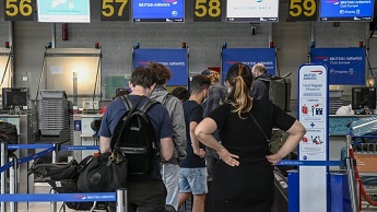 Mask-clad travelers queue at British Airways desks in Terminal 1 of Humberto Delgado International Airport, Lisbon