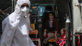 Indian health workers attend to a suspected Covid-19 positive patient