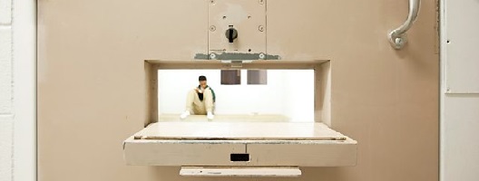 A juvenile inmate in a cell seen through the door hatch. [Image: Richard Ross]