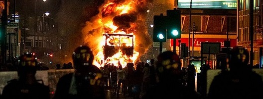 A double-decker bus is engulfed in flames