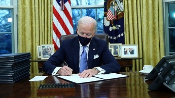 Joe Biden signing executive orders in the Oval Office