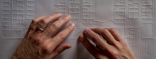 Chris Downey's hands reading an embossed architectural drawing