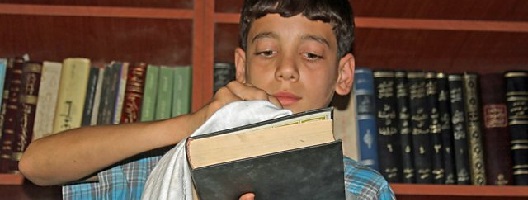 Chief librarian Amjad, 14, in the Secret Library [Image: Daraya Council Media Team]