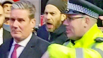 Sir Keir Starmer with a police officer as a protester shouts