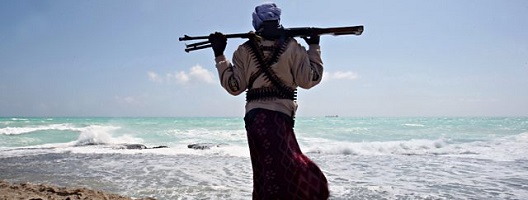 Armed Somali pirate standing on the coast looking to sea. Credit: Mohamed Dahir/AFP via Getty Images