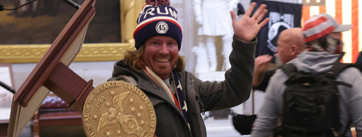 A protester carrying the speaker's lectern in the US Capitol