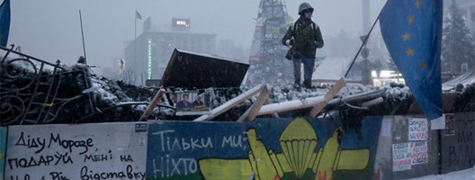 Anti-government protesters stand guard at one of the barricades defending Maidan Square against police. [Image: Etienne De Malglaive/Getty Images]