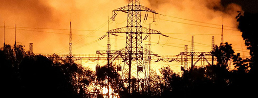 Fire burns behind an electricity pylon