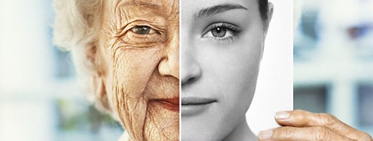 An old woman holds up a black and white picture of her younger self