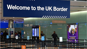 People file through border control at Heathrow Airport