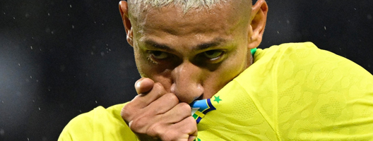Richarlison kisses the Brazil badge on his shirt