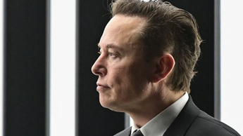 Elon Musk, against a black and white striped background