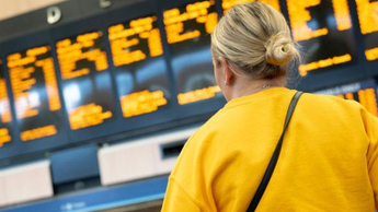 A woman looks at a rail departures board