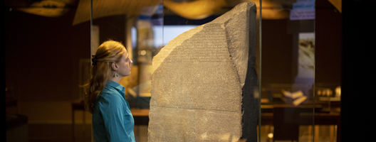 A staff member at the British Museum, in London, looks at the Rosetta Stone