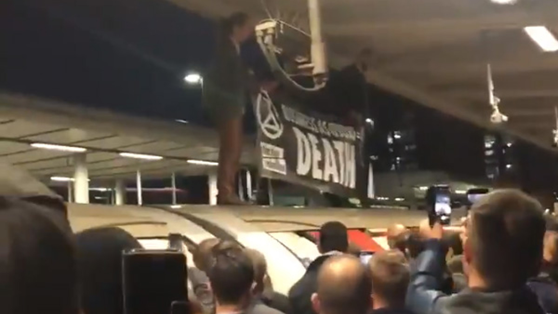 Two protesters on top of a train at Canning Town in east London, October 2019 (Credit: @ChrisChrysanth2 via PA Wire)